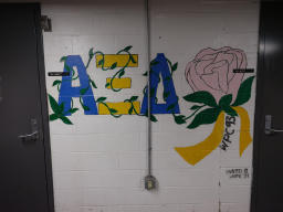 Depicts Alpha Sigma Alpha lettering covered in vines, next to a vine and the
text 
