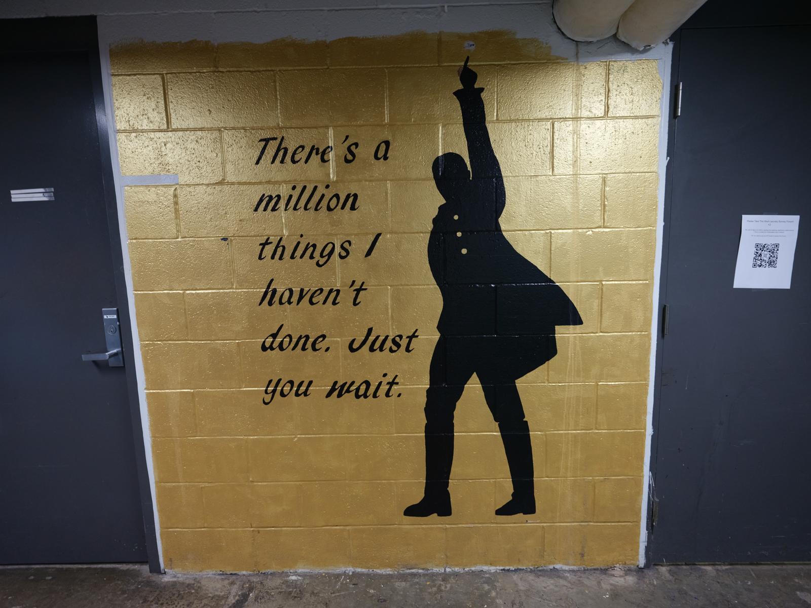 Gold background with a silhouetted man pointing in the air. The text on the
mural reads 