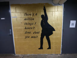 Gold background with a silhouetted man pointing in the air. The text on the
mural reads 